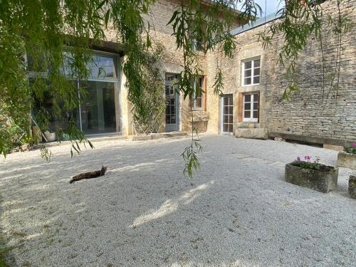 a cat laying on the ground in front of a building at Chez Odette chambre Erable et Glycine in Esnoms-au-Val