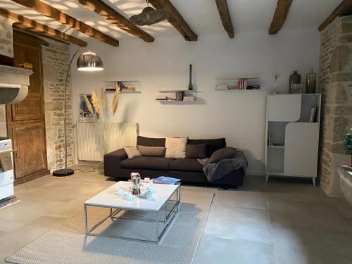 a living room with a couch and a table at Chez Odette chambre Erable et Glycine in Esnoms-au-Val