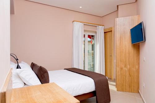 a bedroom with a bed and a table and a tv at Airone Hotel in Naples