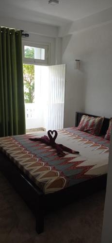 a bed with a ribbon on it with a window at White Surfing Beach Resort in Unawatuna