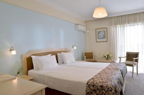 a hotel room with a bed and a desk at Airotel Parthenon in Athens