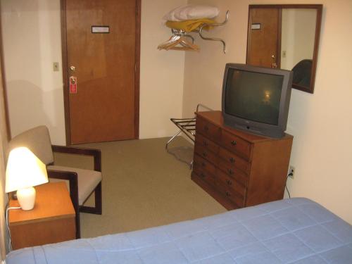 a living room with a tv on a wooden dresser at Big Bears Lodge in West Dover