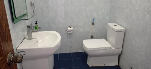 a bathroom with a white toilet and a sink at White Surfing Beach Resort in Unawatuna