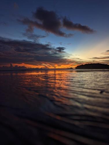 a sunset over a body of water at Ziggy Stardust in Ko Phayam