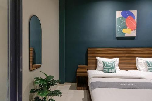 a bedroom with two beds and a blue wall at Mono Coliving Kencana, Surabaya in Gunungsan