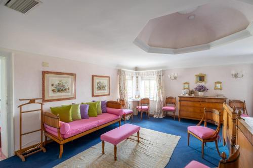 a living room with a pink couch and a piano at Villa il Galero in Asolo