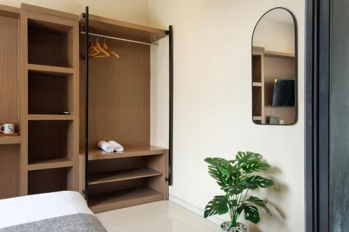 a bedroom with a closet with a mirror and a plant at Mono Coliving Kencana, Surabaya in Gunungsan