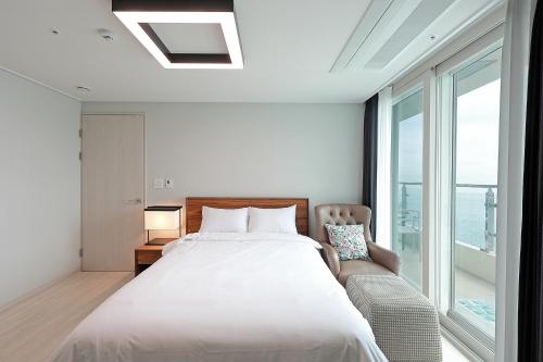 a bedroom with a large bed and a window at Elmomento Songdo in Busan