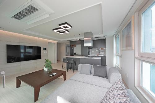 a living room with a couch and a table at Elmomento Songdo in Busan