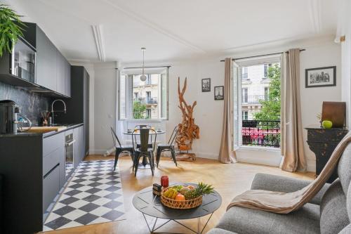 Il comprend une cuisine et un salon avec une table. dans l'établissement Magnifique appartement au cœur du XVIIIème, à Paris