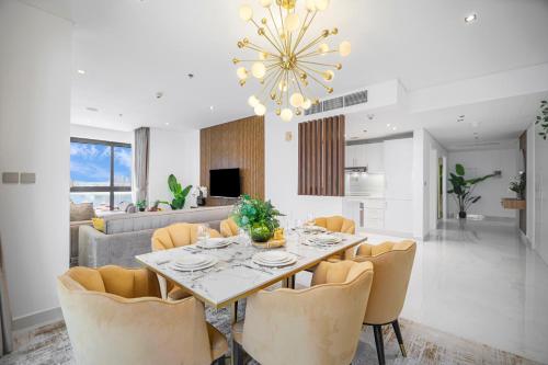 a dining room and living room with a table and chairs at EDEN'S Homes & Villas - Anantara The Palm Residences in Dubai