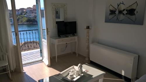 a living room with a television and a balcony at GALAXA Apartments and Studios in Galaxidhion
