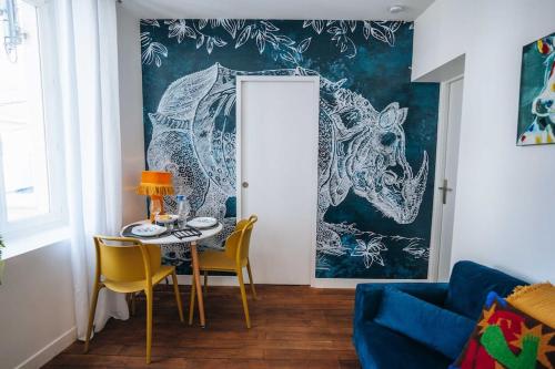 une salle à manger avec une table et des chaises jaunes dans l'établissement Le Blue Bering - Confort & Design - Climatisation, à Châteauroux