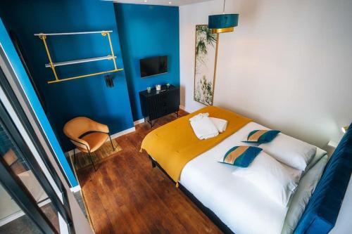 une chambre avec un lit et un mur bleu dans l'établissement Le Blue Bering - Confort & Design - Climatisation, à Châteauroux