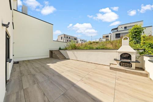 a patio with a fireplace on the side of a building at Villa66 Private Bedroom 4 - Shared Kitchen in Livange