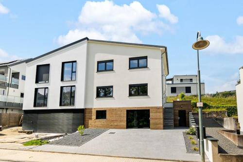 a white house with black windows and a street light at Villa66 Private Bedroom 4 - Shared Kitchen in Livange
