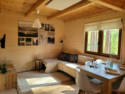 a living room with a couch and a table at Domek pełen szczęścia in Borsk