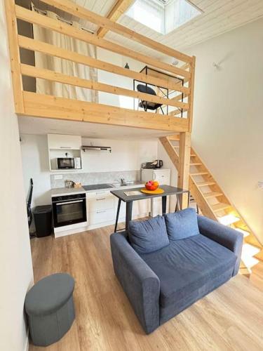 un salon avec un canapé bleu et une table dans l'établissement Le Moulin, appartement rénové au coeur d'Arago, à Les Sables-dʼOlonne