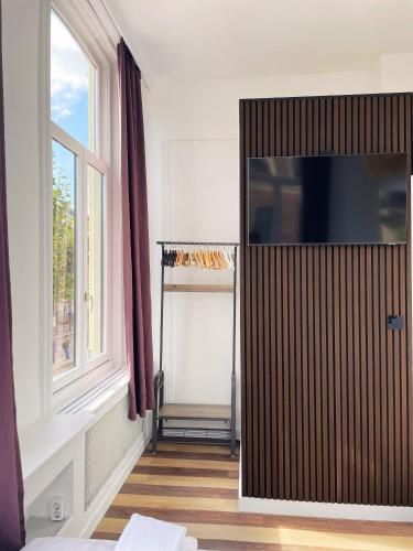 a living room with a flat screen tv on a cabinet at Hotel Plantage in Amsterdam