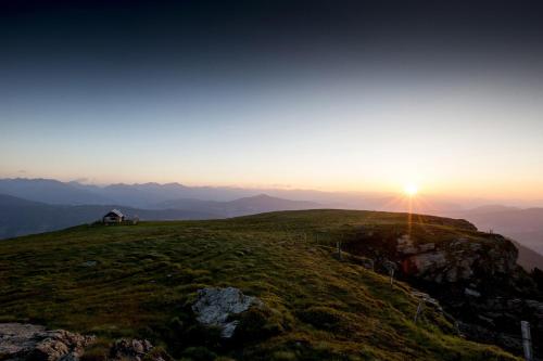 a house on the top of a mountain at sunset at FerienPark Kreischberg by ALPS RESORTS in Sankt Lorenzen ob Murau