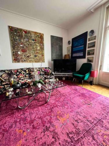 un soggiorno con tappeto rosa e tavolo di Luxury Apartment Montreux a Veytaux