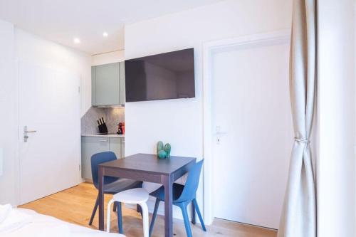 a bedroom with a table and two chairs and a kitchen at HITrental Riesbach Apartments in Zürich