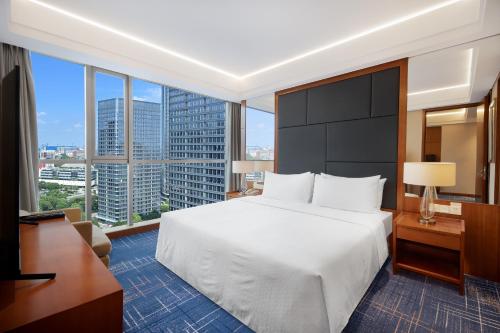 a hotel room with a bed and a large window at Four Points by Sheraton Suzhou in Suzhou