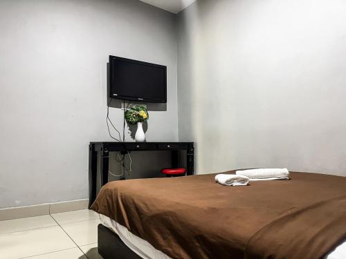 a bedroom with a bed and a flat screen tv at Ho Hotel Batu Berendam C in Malacca