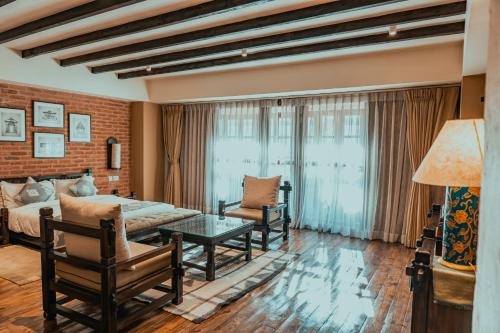 a bedroom with a bed and a couch and a table at Hotel Thamel House - 6 km from Boudhanath Stupa, Kathmandu in Kathmandu