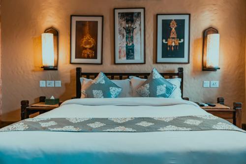a bedroom with a large bed with blue pillows at Hotel Thamel House - 6 km from Boudhanath Stupa, Kathmandu in Kathmandu