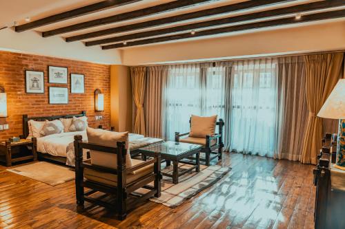 a bedroom with a bed and a couch and a table at Hotel Thamel House - 6 km from Boudhanath Stupa, Kathmandu in Kathmandu