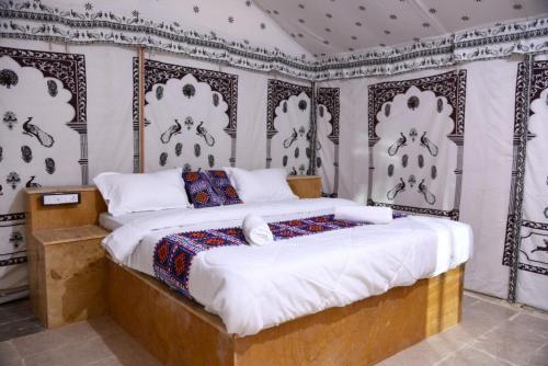 a bedroom with a large bed with black and white wallpaper at Aroma Desert Safari Camp in Sām