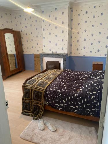 - une chambre avec un lit, une couette et une cheminée dans l'établissement Maison de Fatiha, à Saint-Sornin-Leulac