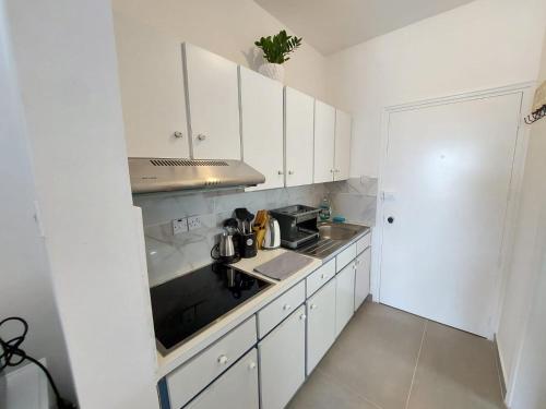 a small kitchen with white cabinets and a sink at JUST on the beach Makenzy Studio in Scala