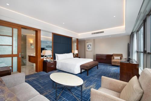 a hotel room with a bed and a living room at Four Points by Sheraton Suzhou in Suzhou