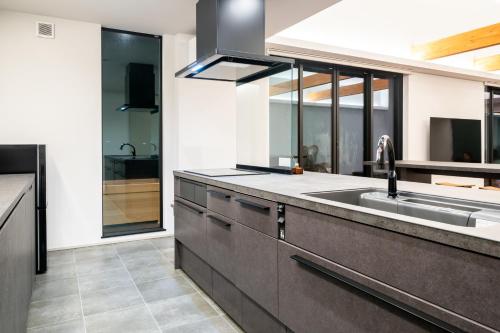 una cocina con fregadero y encimera en EKVOLI MARINA VILLA, Isumi Garden, en Chōjamachi