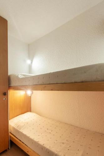 une chambre avec deux lits superposés dans une pièce dans l'établissement Chaleureux studio, wifi, local à ski, pieds pistes, à Isola 2000