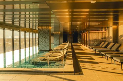 a hotel lobby with chairs and a pool at Stadium City Hotel Nagasaki in Nagasaki
