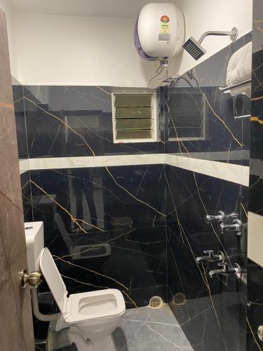 a bathroom with a black and white tiled wall at Royal Galaxy Homes in Bhubaneshwar