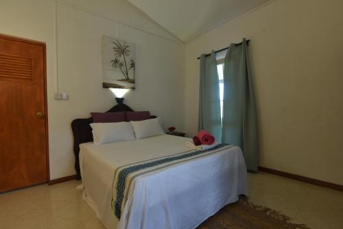 a bedroom with a bed with a red hat on it at La Villa Côtière 2 in Flic-en-Flac