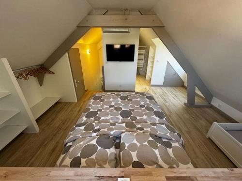 ein Dachzimmer mit einem Bett in der Mitte in der Unterkunft Villa Beauséjour in Saint-Hilaire-Saint-Mesmin