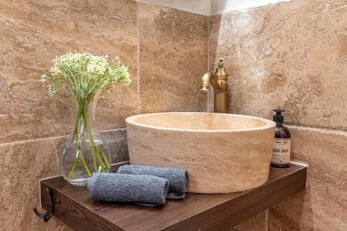 a bathroom with a sink and a vase of flowers at Апартаменти Стефани in Plovdiv