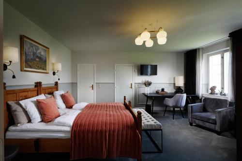 a bedroom with a bed and a living room at Gl. Avernæs Sinatur Hotel & Konference in Ebberup