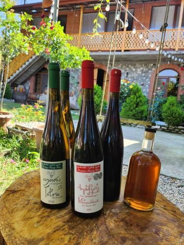 three bottles of wine sitting on a wooden table at Lomtadze Family Wine Hotel in Ambrolauri