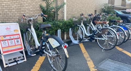 a row of bikes parked in a parking lot at kotobuki504condotel in Imai-kamichō