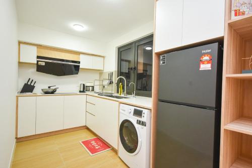 a kitchen with a refrigerator and a washer and dryer at Sunway Grid Loft Suite by Nest Home【Olympic Size Pool】 in Kampong Pendas
