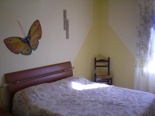 1 dormitorio con 1 cama con una mariposa en la pared en Nido Del Merlo, en Santomato 