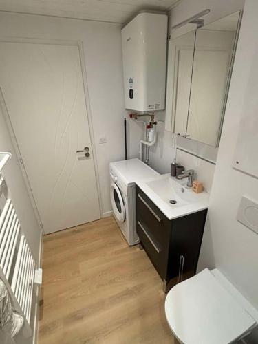 une petite cuisine avec un évier et une machine à laver dans l'établissement L'Hirondelle, studio rénové au coeur d'Arago, à Les Sables-dʼOlonne