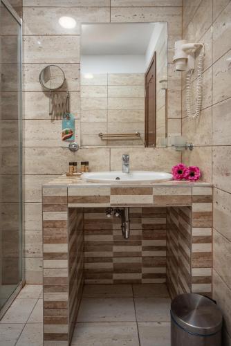 a bathroom with a sink and a mirror at Termál Hotel Vesta in Tápiószecső