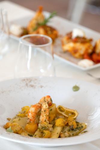 a plate of food with shrimp and vegetables on a table at Q Resort in Marina di Sorso